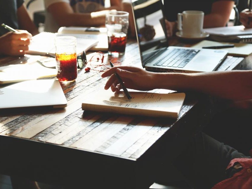 A team working together at a table with laptops